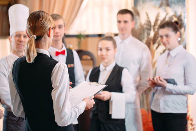Gestora atribuindo tarefas e gerenciando atividades em um hotel