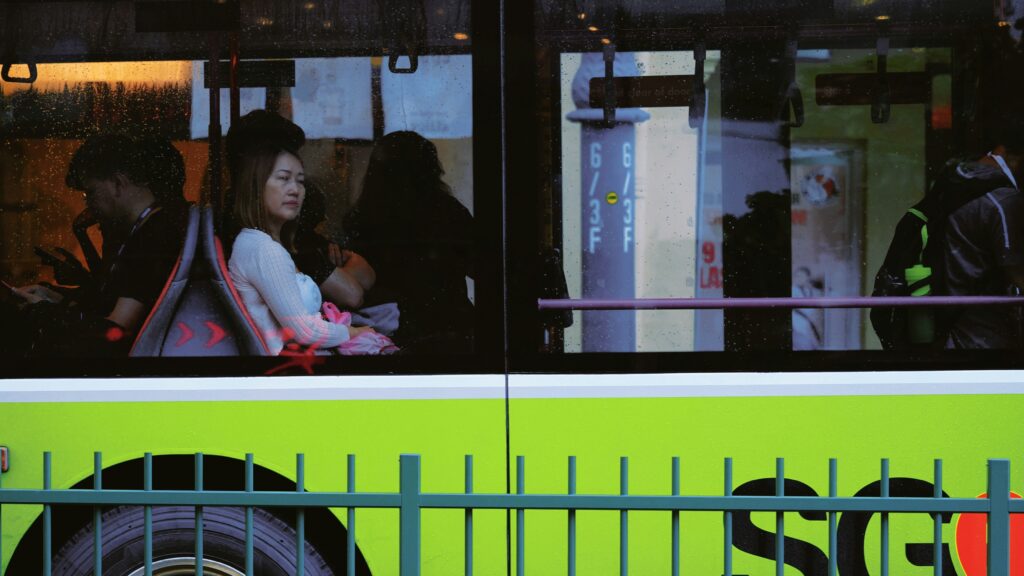 Passageiros desanimados olham pela janela do ônibus